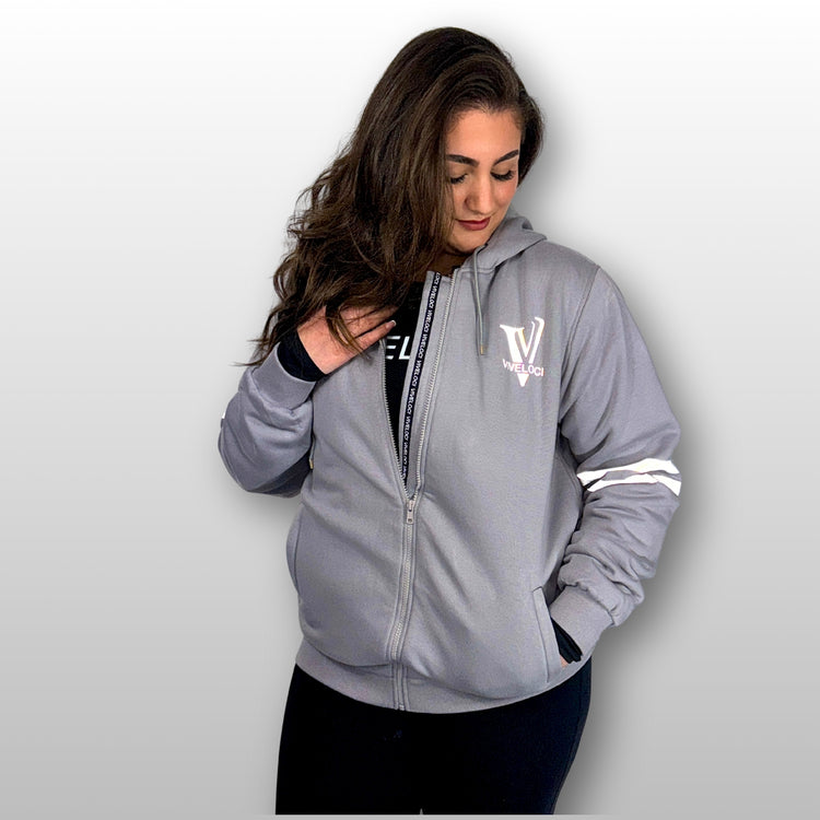 Bernadette is wearing a ViVeloci Kevlar Lined, Armored, Motorcycle Hoodie in Silver Grey.  Reflective back, front and arm bands.  Removable CE Level 1 Armor in Shoulders, Elbows and Back. Two zippered pockets on the outside and one on the inside.