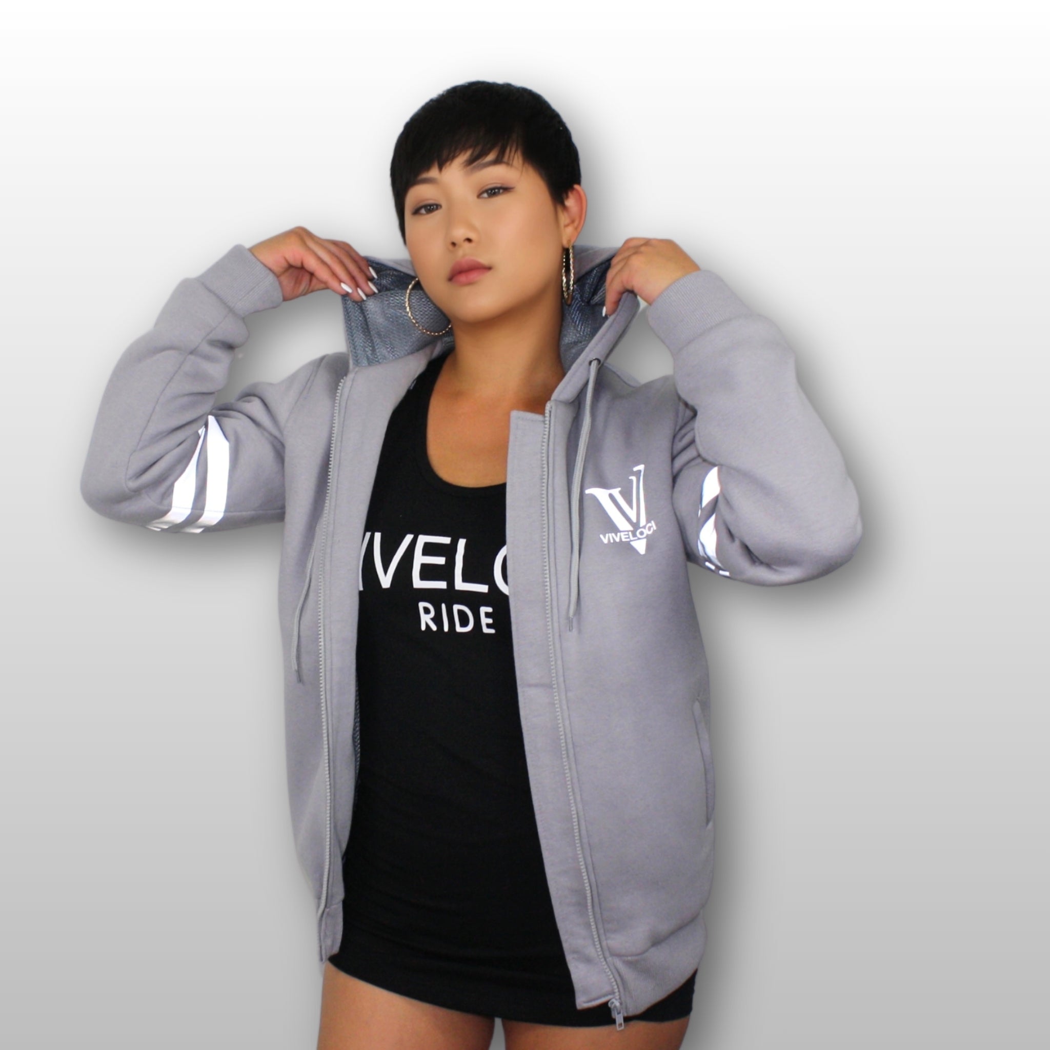 Hanna is wearing a silver grey ViVeloci Kevlar Lined, Armored, Motorcycle Hoodie. Reflective back, front and arm bands.  Removable CE Level 1 Armor in Shoulders, Elbows and Back. Two zippered pockets on the outside and one on the inside.
