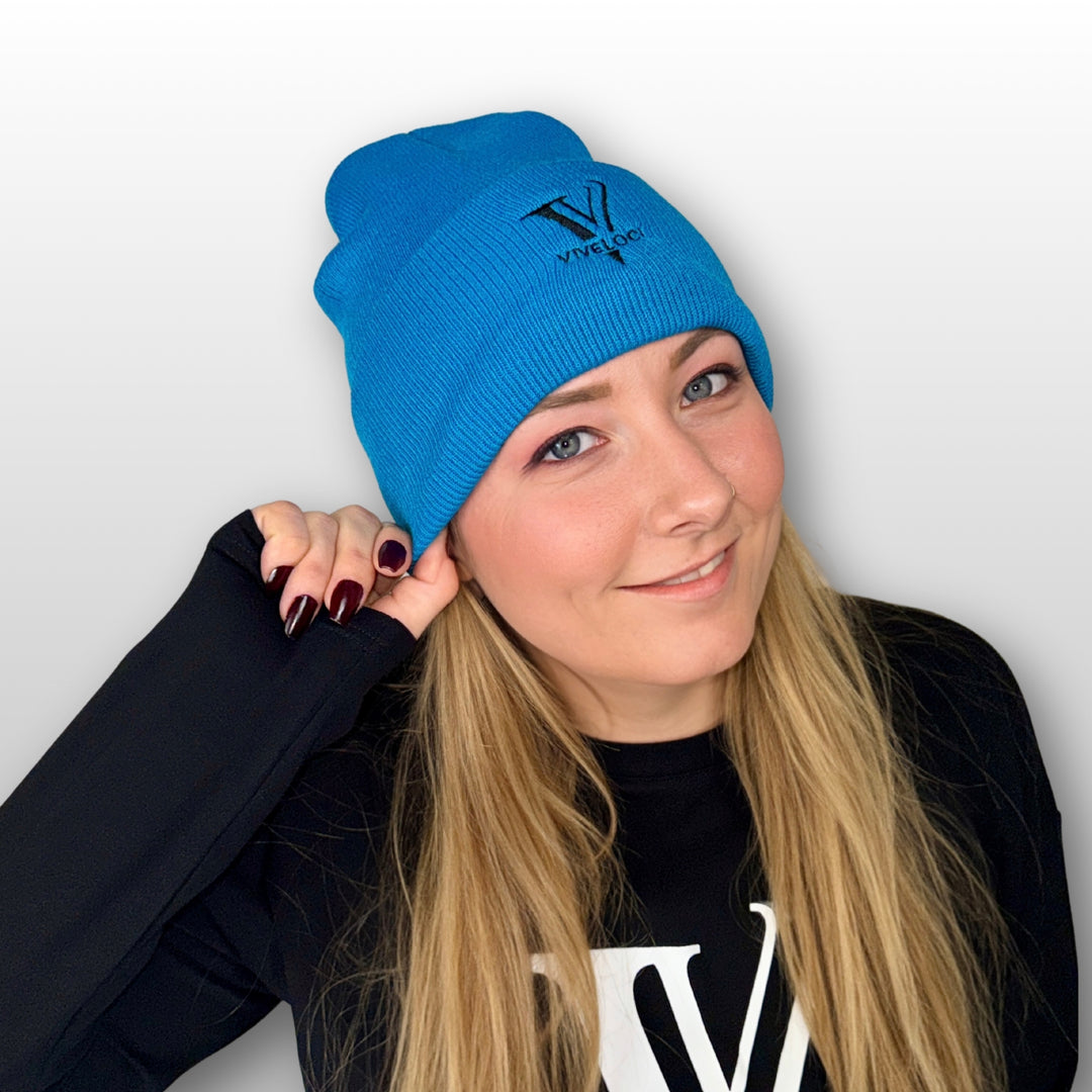 Amy wearing a teal Viveloci beanie and black Viveloci long sleeve crop top.