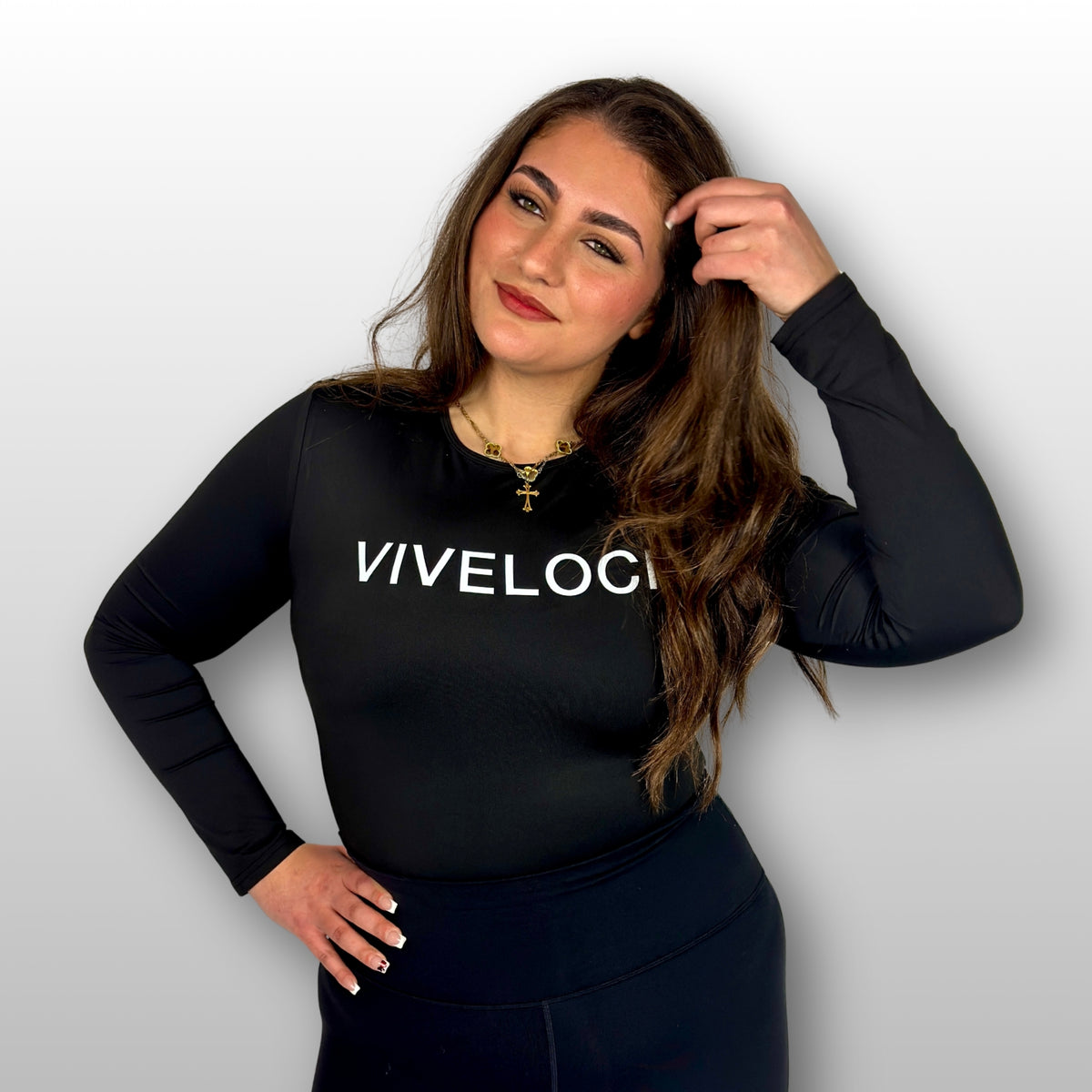 Bernadette wearing a black long-sleeve bodysuit with 'VIVELOCI' text on a plain background
