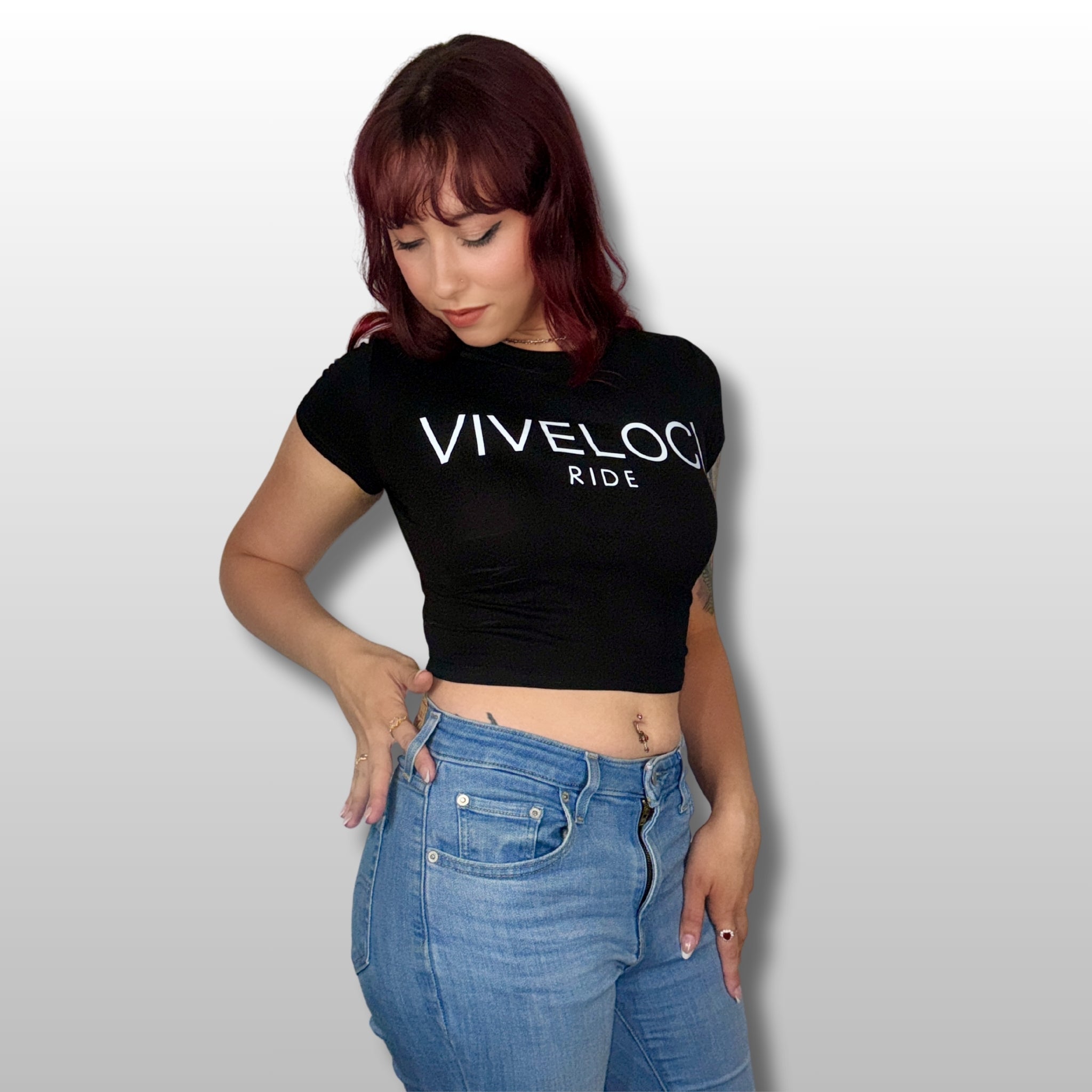 Megan wearing a black ViVeloci RIDE short sleeved crop top against a grey background.