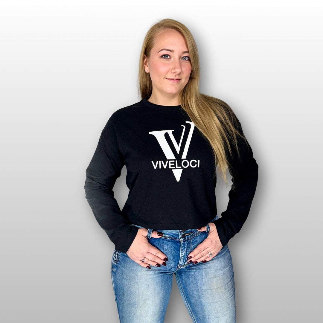 Amy wearing a black ViVeloci long sleeved crop top against a grey background.