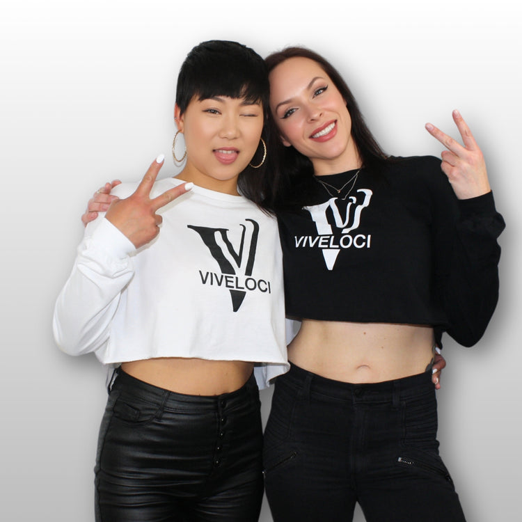 Hanna & Tiffani wearing Viveloci crop tops posing against a grey background