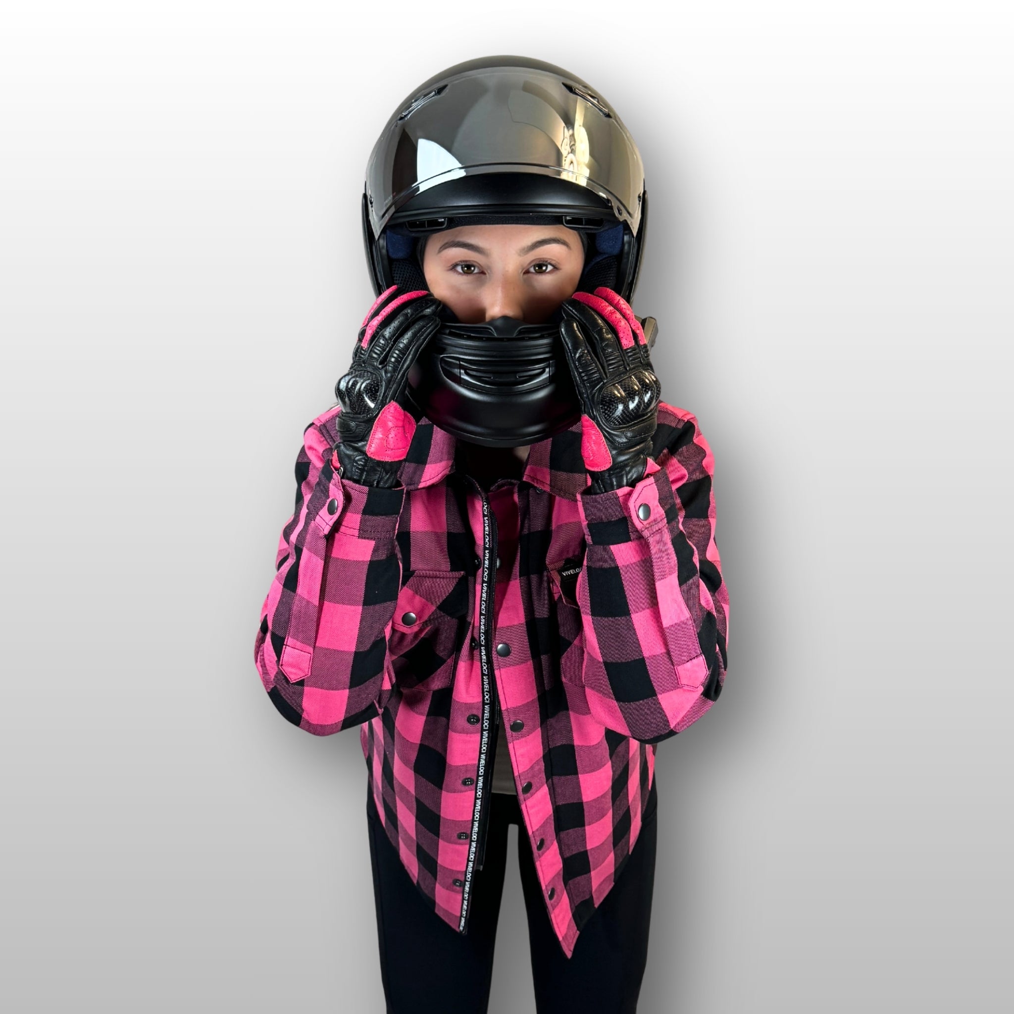 Julie wearing a Pink Viveloci Riding Flannel and Pink Ciao Bella Riding gloves with a black motorcycle helmet.