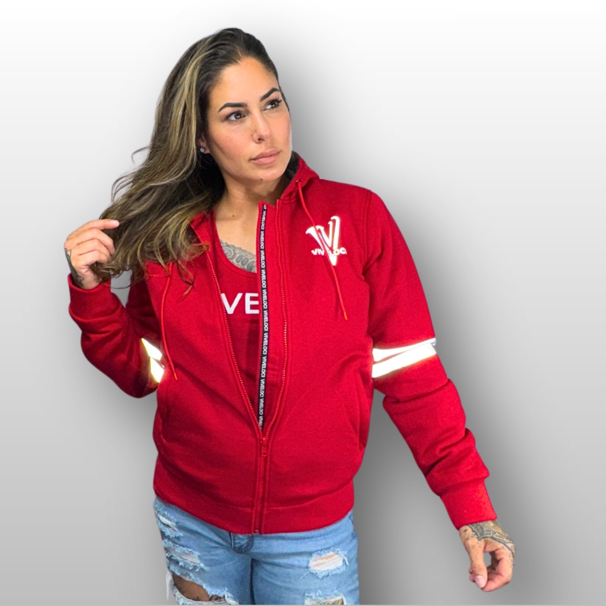 Nina is wearing a ViVeloci Kevlar Lined, Armored, Motorcycle Hoodie in Red.  Reflective back, front and arm bands.  Removable CE Level 1 Armor in Shoulders, Elbows and Back. Two zippered pockets on the outside and one on the inside.