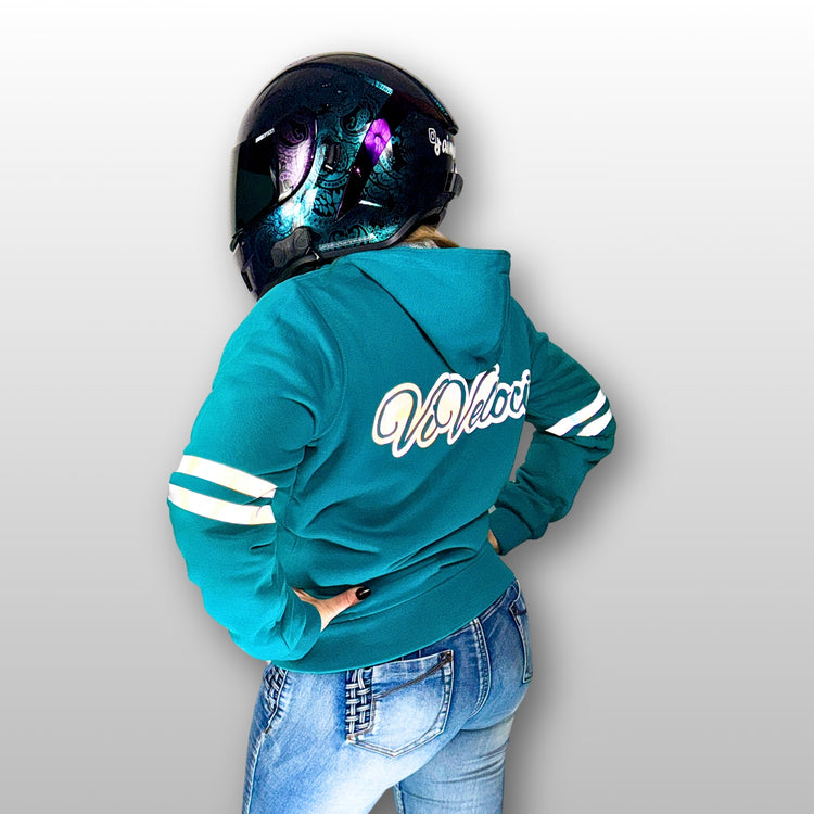 Amy is wearing a ViVeloci Kevlar Lined, Armored, Motorcycle Hoodie in Teal, wearing a motorcycle helmet against a grey background.