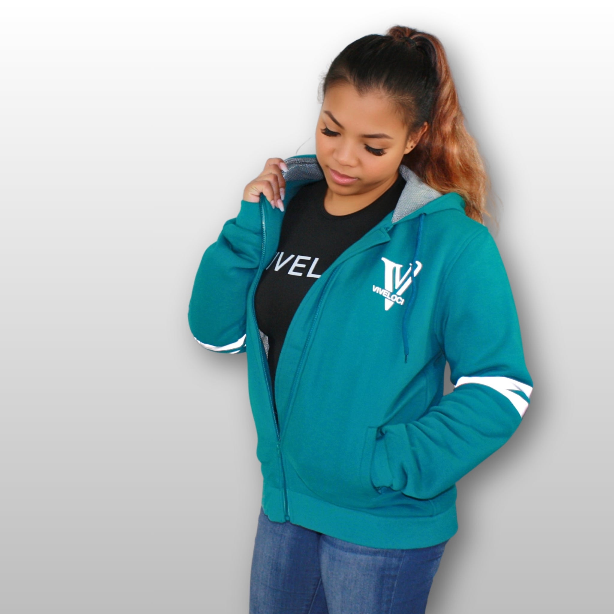 Ro is wearing a ViVeloci Kevlar Lined, Armored, Motorcycle Hoodie in Teal.  Reflective back, front and arm bands.  Removable CE Level 1 Armor in Shoulders, Elbows and Back. Two zippered pockets on the outside and one on the inside.