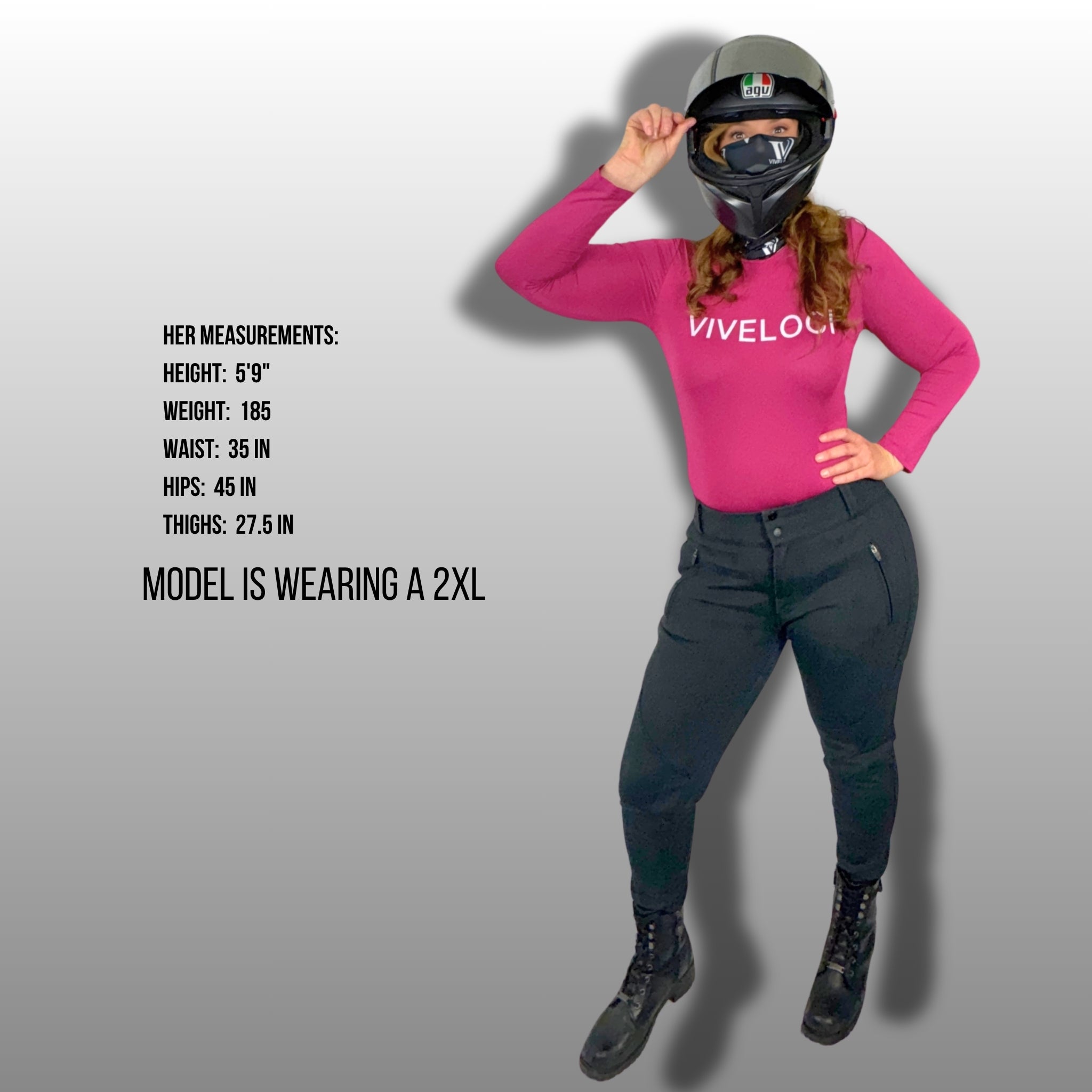 Woman wearing pink ViVeloci bodysuit, black riding pants and motorcycle helmet with model measurements displayed on a gray background