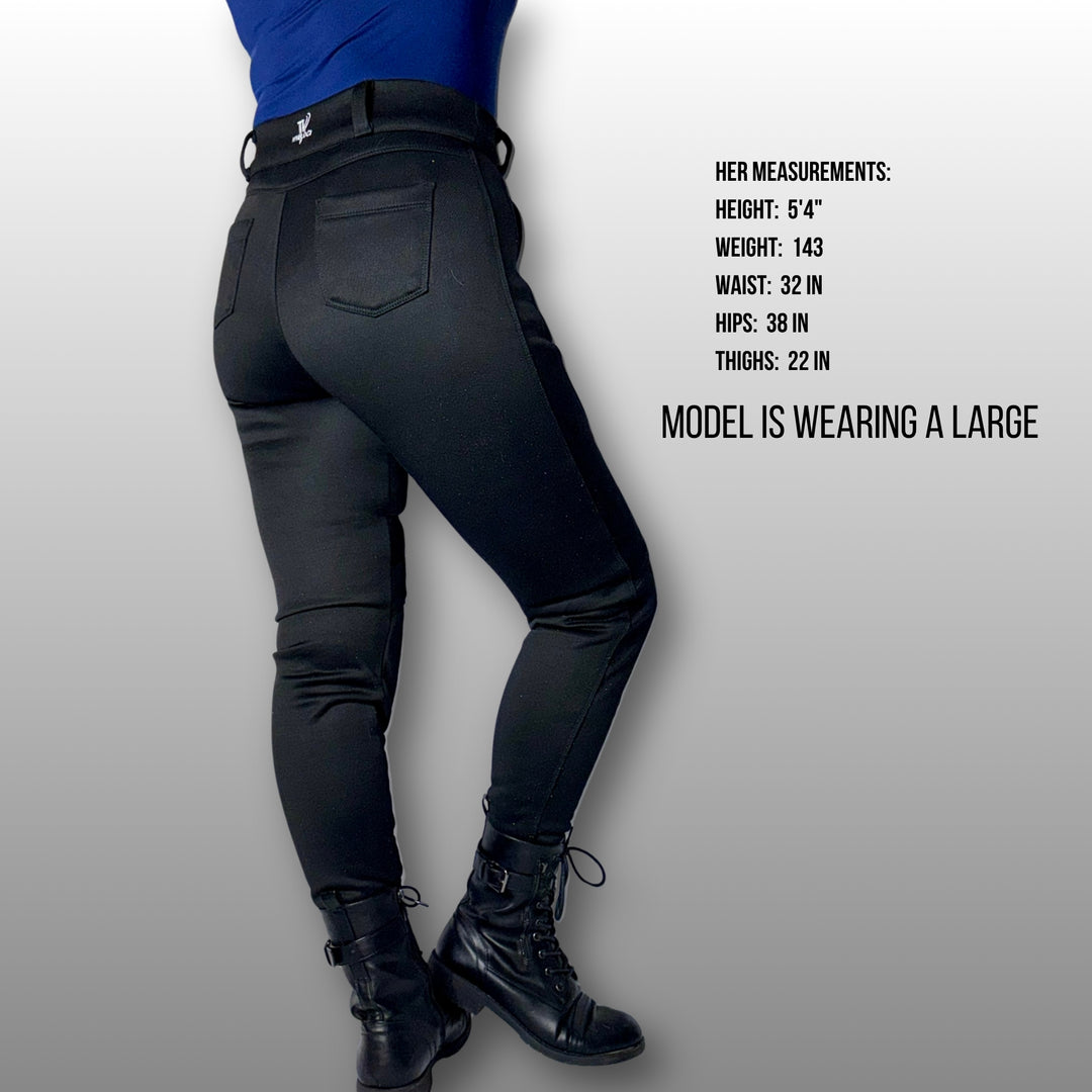 Woman wearing black riding pants with model measurements displayed on a gray background