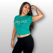 Lani wearing a teal ViVeloci Crop top and black leggings against a gray background