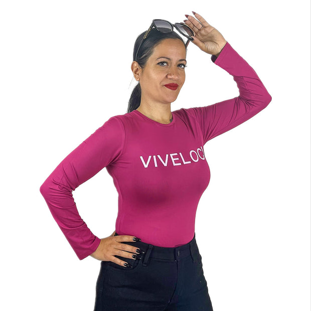 Woman wearing pink bodysuit holding sunglasses on her head