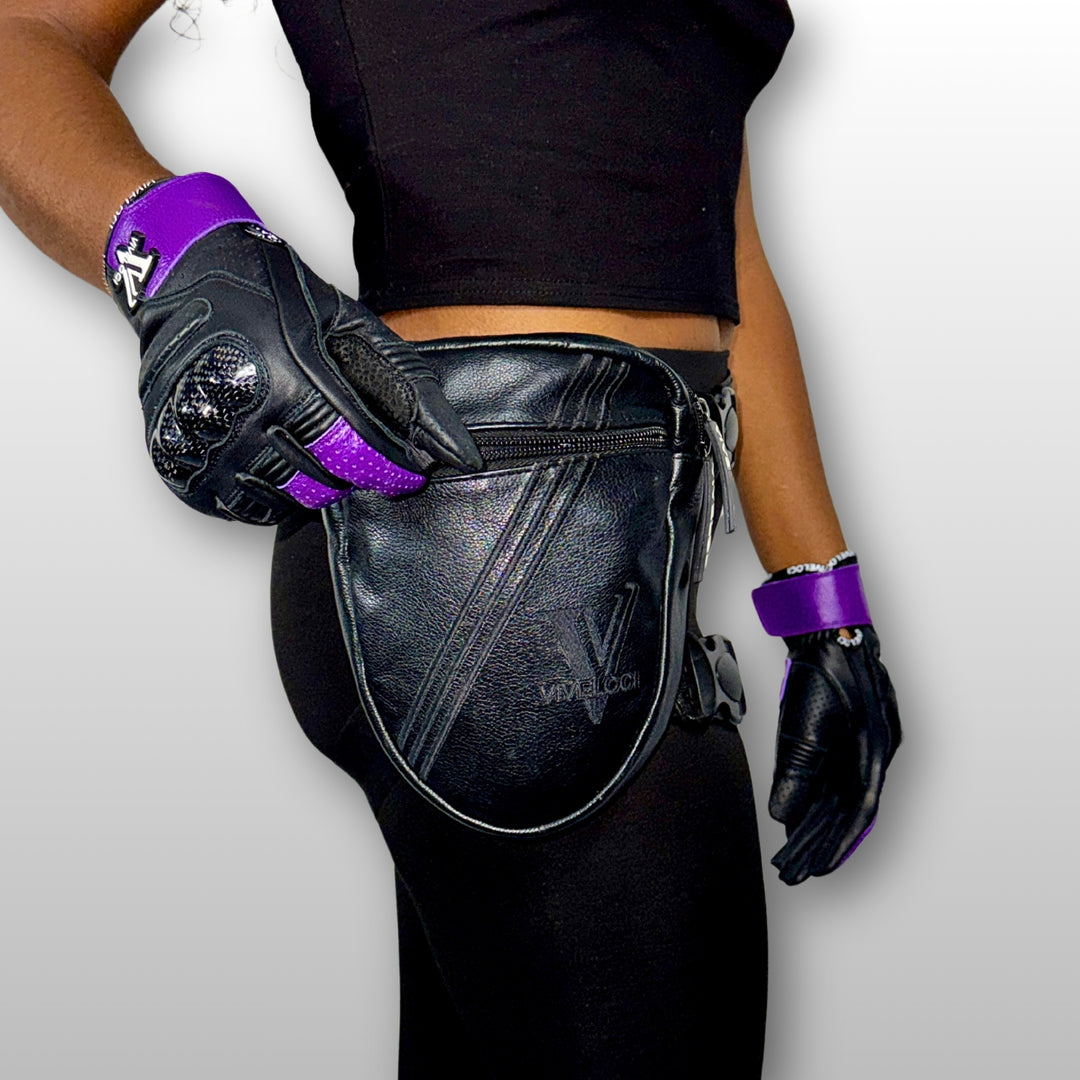 Woman wearing black leather thigh bag and purple motorcycle gloves 