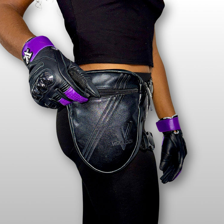 Woman wearing black leather thigh bag and purple motorcycle gloves 