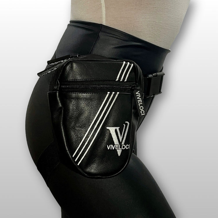 A black leather thigh bag with white diagonal stripes and a white 'VIVELOC1' logo, worn on a model's hip.