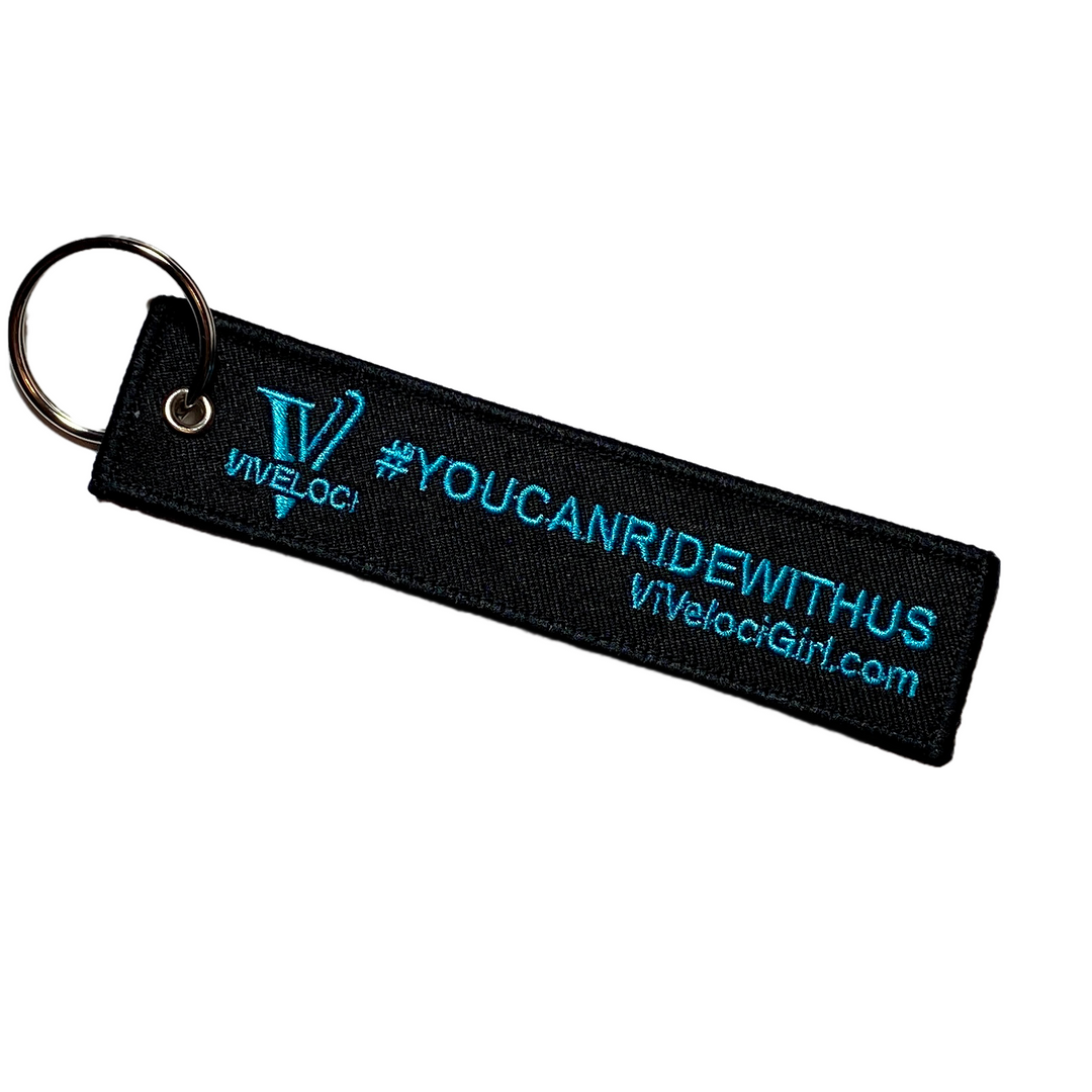 Viveloci You can ride with us key tag/key chain. Black with teal embroidered lettering.